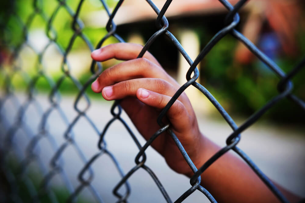 Hand on Chain Link Fence
